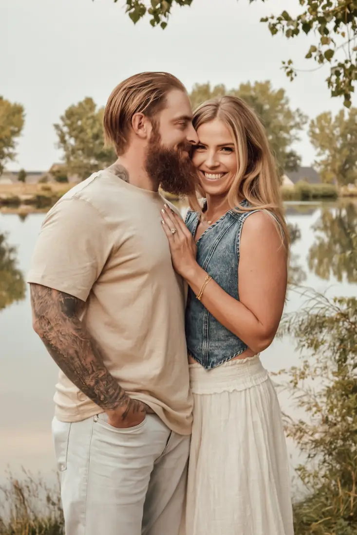Couple embracing by a lake at golden hour