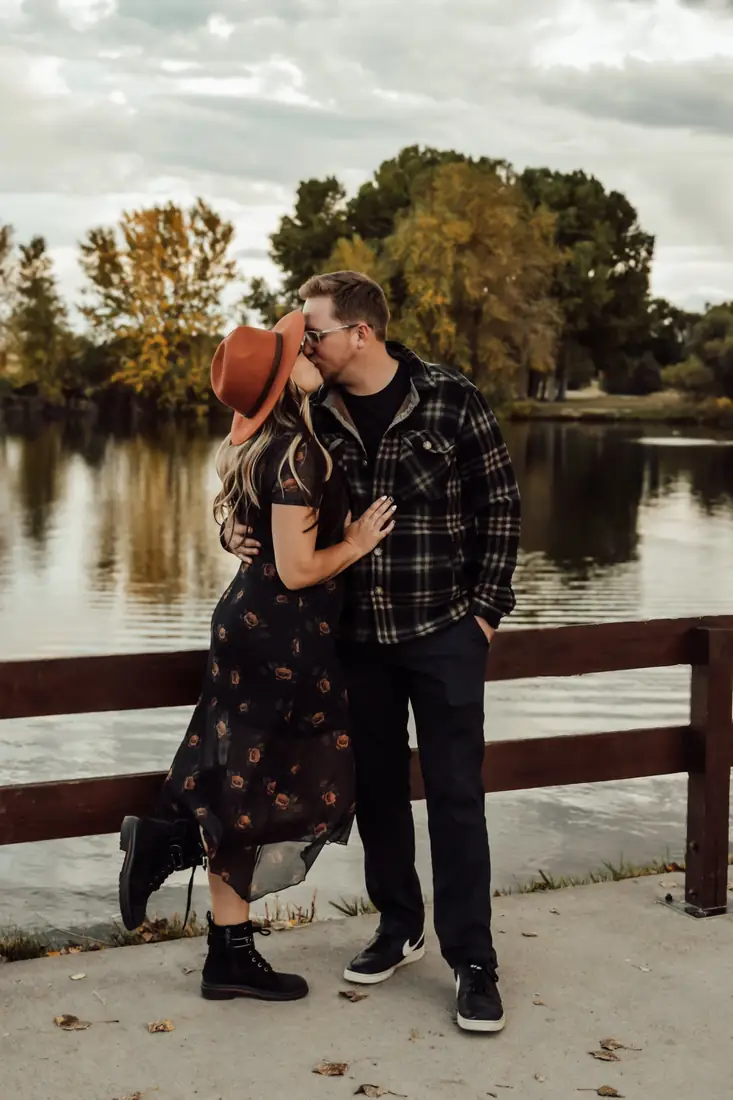 Couple kissing beside a lake in autumn